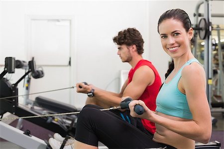 simsearch:400-07725772,k - Smiling brunette working out on the rowing machine at the gym Photographie de stock - Aubaine LD & Abonnement, Code: 400-07583209