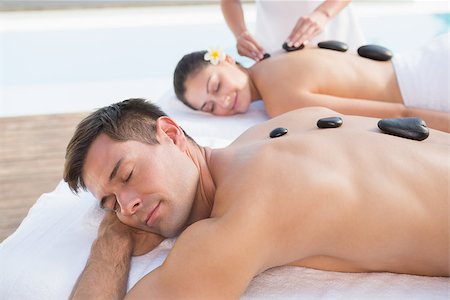 Attractive couple enjoying hot stone massage poolside outside at the spa Stock Photo - Budget Royalty-Free & Subscription, Code: 400-07583370