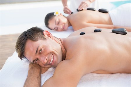 Attractive couple enjoying hot stone massage poolside outside at the spa Stock Photo - Budget Royalty-Free & Subscription, Code: 400-07583371