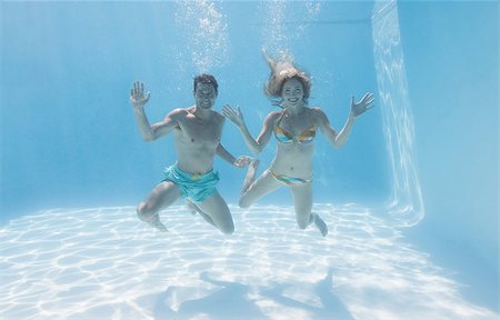 simsearch:400-07583483,k - Cute couple smiling at camera underwater in the swimming pool on their holidays Foto de stock - Royalty-Free Super Valor e Assinatura, Número: 400-07583457