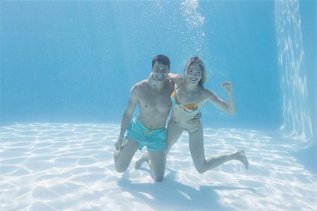 simsearch:400-07583483,k - Cute couple smiling at camera underwater in the swimming pool on their holidays Foto de stock - Royalty-Free Super Valor e Assinatura, Número: 400-07583459