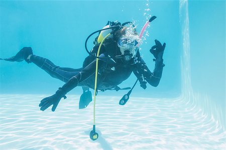 Woman on scuba training submerged in swimming pool making ok sign on her holidays Stock Photo - Budget Royalty-Free & Subscription, Code: 400-07583474