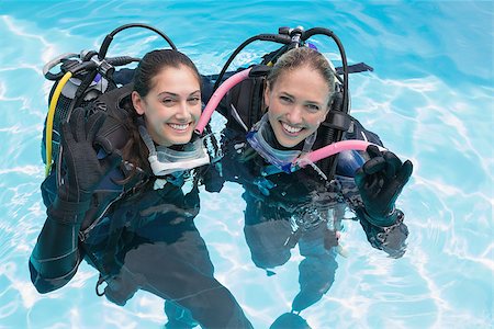 simsearch:400-07583483,k - Smiling friends on scuba training in swimming pool making ok sign on a sunny day Foto de stock - Royalty-Free Super Valor e Assinatura, Número: 400-07583470