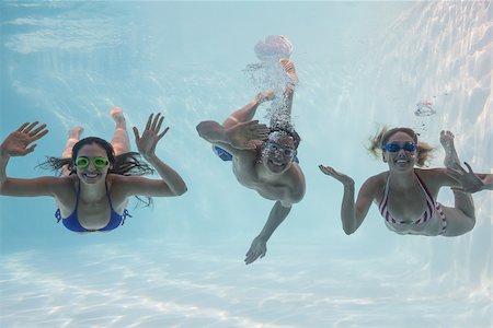 simsearch:400-07583483,k - Smiling friends looking at camera underwater in swimming pool on their holidays Foto de stock - Royalty-Free Super Valor e Assinatura, Número: 400-07583620