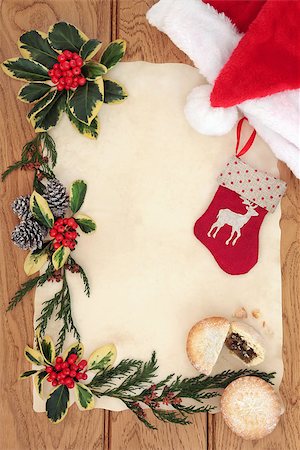 Christmas eve background border with red santa hat and stocking decoration, mince pie, holly, cedar and pine cones over old parchment and oak. Stock Photo - Budget Royalty-Free & Subscription, Code: 400-07614339