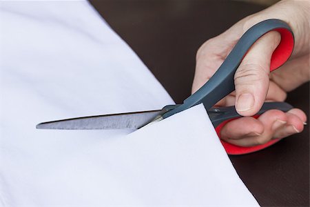 simsearch:400-05185463,k - Hand cut white fabric with scissors of dressmaker cutting a cloth Photographie de stock - Aubaine LD & Abonnement, Code: 400-07615598