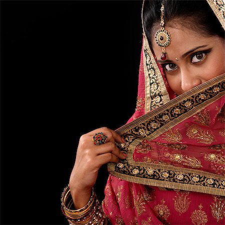 pictures of beautiful girls indian local - Portrait of beautiful mystery young Indian woman covering her face by veil, looking at camera, copy space at side, isolated on black background. Stock Photo - Budget Royalty-Free & Subscription, Code: 400-07616579