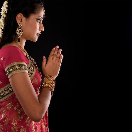 simsearch:400-08223620,k - Beautiful Indian girl in greeting pose, traditional sari prayer isolated on black background with copy space on side. Stock Photo - Budget Royalty-Free & Subscription, Code: 400-07616573