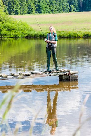 pescatrice - young woman fishing on pier at pond Fotografie stock - Microstock e Abbonamento, Codice: 400-07617803