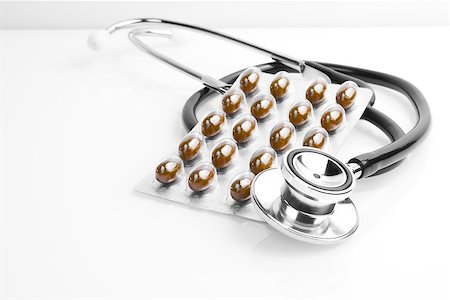 simsearch:400-06916693,k - a pills blister near stethoscope on the white table Stock Photo - Budget Royalty-Free & Subscription, Code: 400-07618393