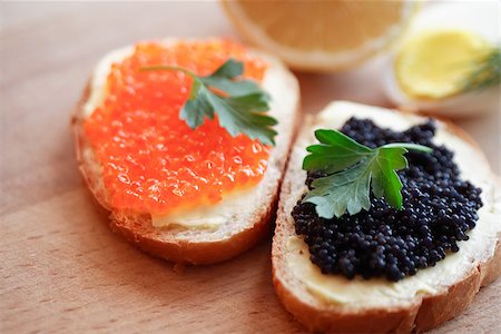 Two sandwiches with red and black caviar on wooden board near lemon and egg Stock Photo - Budget Royalty-Free & Subscription, Code: 400-07618525