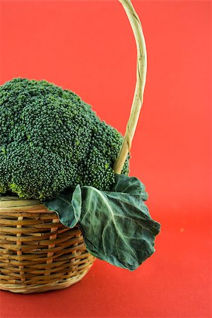 simsearch:400-07822704,k - Fresh broccoli in Straw basket on red background. Photographie de stock - Aubaine LD & Abonnement, Code: 400-07613187