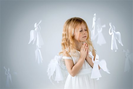 photos of little girl praying - Angels in the studio isolated Foto de stock - Super Valor sin royalties y Suscripción, Código: 400-07624366