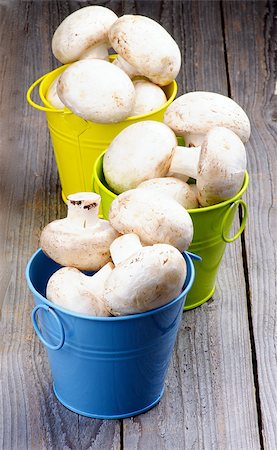 simsearch:400-08011809,k - Big Raw Champignons in Blue, Green and Yellow Buckets isolated on Rustic Wooden background Photographie de stock - Aubaine LD & Abonnement, Code: 400-07625349