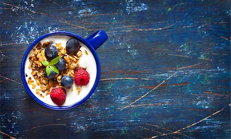 Yogurt with granola and fresh berries on an old wooden board with copy space for text. Stock Photo - Budget Royalty-Free & Subscription, Code: 400-07626128