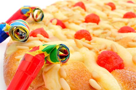 closeup of a coca de Sant Joan, a typical sweet flat cake from Catalonia, Spain, eaten on Saint Johns Eve, and some party horns Stock Photo - Budget Royalty-Free & Subscription, Code: 400-07628011