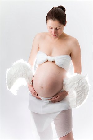 Pregnancy. Woman with wings attached to belly. Foto de stock - Super Valor sin royalties y Suscripción, Código: 400-07620629
