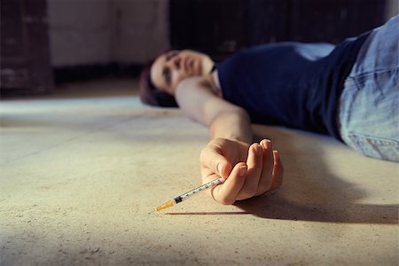 drugs (recreational) - Closeup of young girl in heroine overdose holding syringe and lying on pavement. Copy space Stock Photo - Budget Royalty-Free & Subscription, Code: 400-07620794