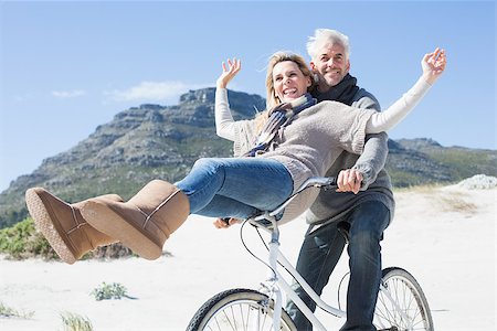 Carefree couple going on a bike ride on the beach on a bright but cool day Stock Photo - Budget Royalty-Free & Subscription, Code: 400-07622727