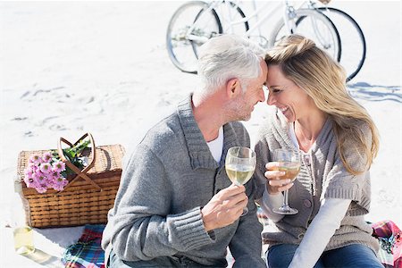 Couple enjoying white wine on picnic at the beach smiling at each other on a bright but cool day Stock Photo - Budget Royalty-Free & Subscription, Code: 400-07622754