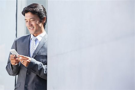 simsearch:400-07475963,k - Asian businessman sending text message outside a house Stock Photo - Budget Royalty-Free & Subscription, Code: 400-07622900