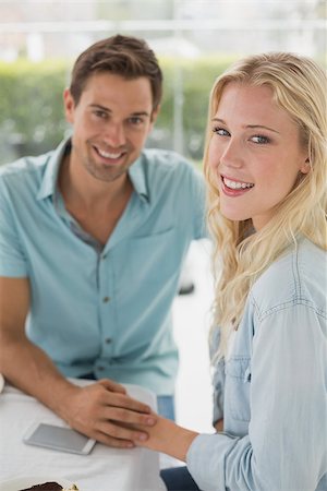 Hip young couple sitting at table smiling at camera on the cafe terrace on sunny day Stock Photo - Budget Royalty-Free & Subscription, Code: 400-07623497