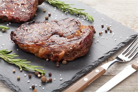 steak knife - Beef steaks with rosemary and spices on wooden table Stock Photo - Budget Royalty-Free & Subscription, Code: 400-07623515