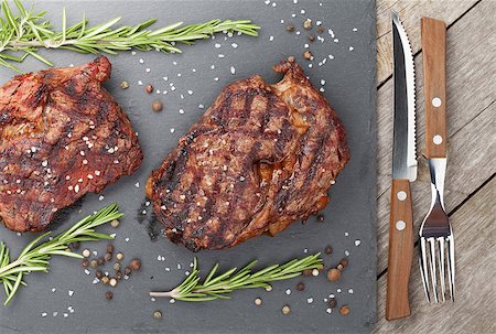 steak fork - Beef steaks with rosemary and spices on wooden table Stock Photo - Budget Royalty-Free & Subscription, Code: 400-07623518