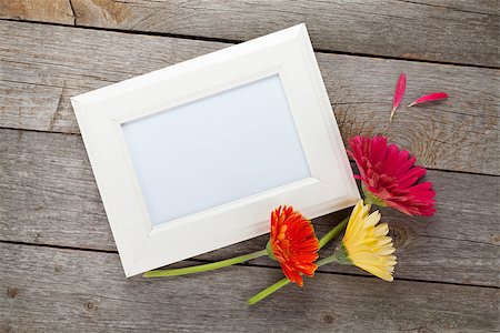 simsearch:400-07662543,k - Three colorful gerbera flowers and photo frame on wooden table Stock Photo - Budget Royalty-Free & Subscription, Code: 400-07623538
