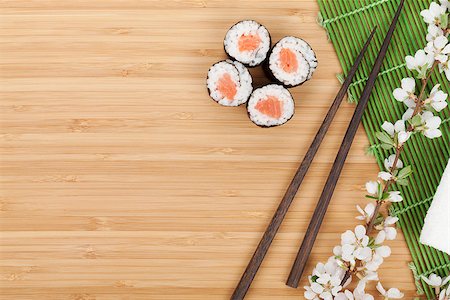 simsearch:400-07719212,k - Sushi set, chopsticks and sakura branch over bamboo table with copy space Fotografie stock - Microstock e Abbonamento, Codice: 400-07623825