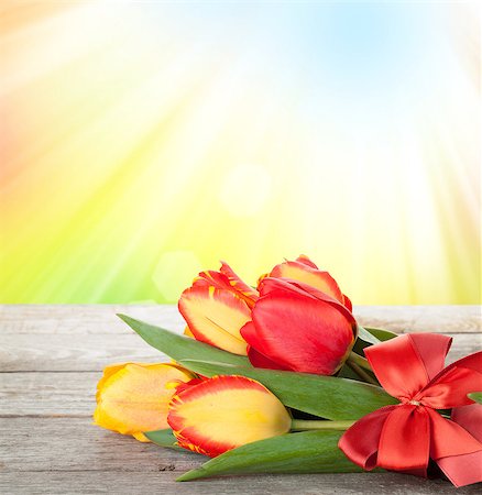 Fresh tulips bouquet over wooden table with sunny bokeh Stock Photo - Budget Royalty-Free & Subscription, Code: 400-07623896
