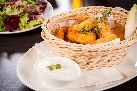 simsearch:400-05708291,k - Crispy fried crumbed chicken nuggets in a wicker basket served as a finger food or appetizer with a creamy dip in a bowl alongside Stock Photo - Budget Royalty-Free & Subscription, Code: 400-07630001