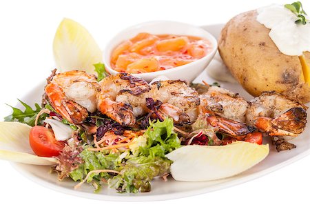 snacks and salads recipes - Grilled prawns with a green leafy lettuce and endive salad and a jacket potato topped with sour cream served on a white plate, close up high angle view on white Stock Photo - Budget Royalty-Free & Subscription, Code: 400-07630036