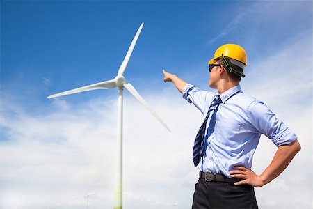 recycle energy conservation - young engineer standing and point to wind generator Stock Photo - Budget Royalty-Free & Subscription, Code: 400-07630708