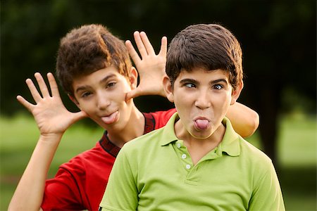 Portrait of happy hispanic children, two brothers, making a face and grimacing at camera outdoors in park Fotografie stock - Microstock e Abbonamento, Codice: 400-07630750