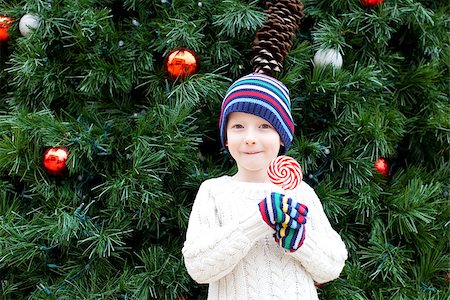 little cheerful boy holding candy and enjoying christmas time Stock Photo - Budget Royalty-Free & Subscription, Code: 400-07631132