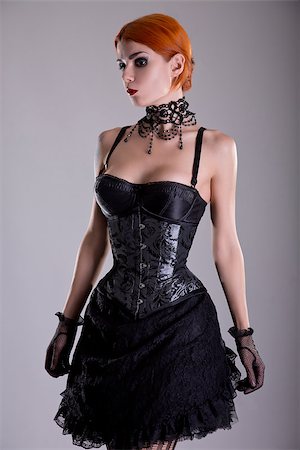 Pretty redhead young woman in silver corset and black skirt, studio shot Stock Photo - Budget Royalty-Free & Subscription, Code: 400-07632540