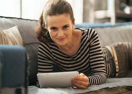 simsearch:400-08054469,k - Young woman laying on couch and using tablet pc in loft apartment Stock Photo - Budget Royalty-Free & Subscription, Code: 400-07632636