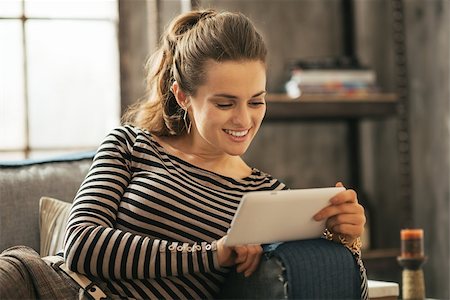 person tablet home information - Happy young woman sitting on sofa and using tablet pc in loft apartment Stock Photo - Budget Royalty-Free & Subscription, Code: 400-07632645