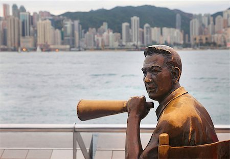 HONG KONG - Statue and skyline in Avenue of Stars  in Hong Kong, China. The promenade honours celebrities of the Hong Kong film industry as the famous city attraction. Foto de stock - Super Valor sin royalties y Suscripción, Código: 400-07633401