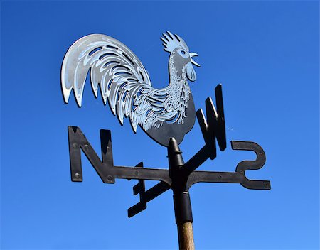 photos of cock wind direction - Detail of windmill cock with indicator on west, north, south and east. Blue sky background. Stock Photo - Budget Royalty-Free & Subscription, Code: 400-07657163