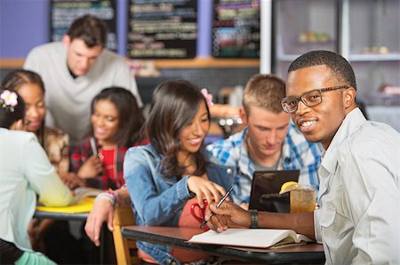 Cute man doing homework with friends in cafe Stock Photo - Budget Royalty-Free & Subscription, Code: 400-07657945