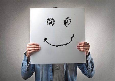Man holding a cardboard with a drawn smile Stock Photo - Budget Royalty-Free & Subscription, Code: 400-07658517