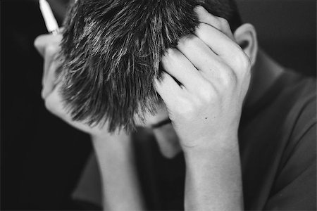 simsearch:640-01350613,k - Black and white portrait of a teenage boy leaning his head against his fists , expressing frustration. Photographie de stock - Aubaine LD & Abonnement, Code: 400-07659045