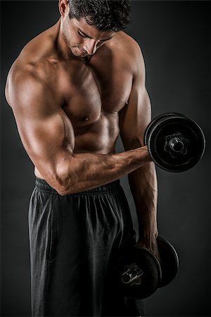 Portrait of a muscular man lifting weights against a dark background Stock Photo - Budget Royalty-Free & Subscription, Code: 400-07659267