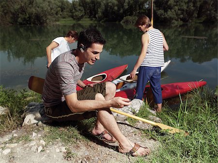 Young men with friends near river, discussing how to paddle in a kayak Stock Photo - Budget Royalty-Free & Subscription, Code: 400-07659829