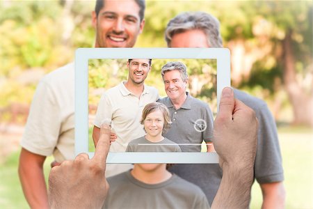 family with tablet in the park - Hand holding tablet pc showing family looking at the camera in the park Stock Photo - Budget Royalty-Free & Subscription, Code: 400-07664001