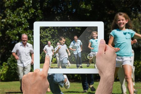 simsearch:400-07664794,k - Hand holding tablet pc showing happy multi generation family racing towards camera Stock Photo - Budget Royalty-Free & Subscription, Code: 400-07664786