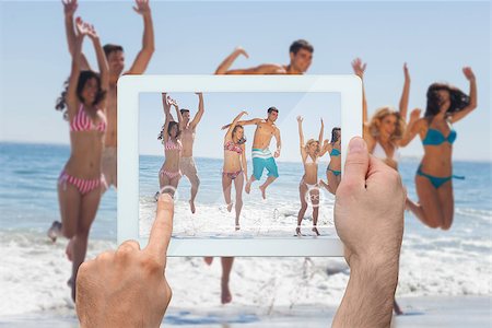simsearch:400-07664794,k - Hand holding tablet pc showing happy friends jumping on the beach Stock Photo - Budget Royalty-Free & Subscription, Code: 400-07664788