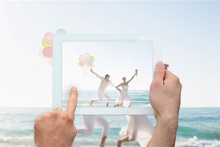 simsearch:400-07664797,k - Hand holding tablet pc showing newlyweds having fun holding balloons Stock Photo - Budget Royalty-Free & Subscription, Code: 400-07664797